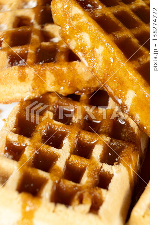 Delicious Belgian waffles topped with sweet caramel syrup close up. Delicious Belgian waffles topped with sweet caramel syrup close up. 138274722