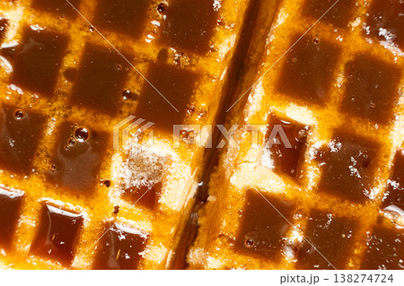 Delicious Belgian waffles topped with sweet caramel syrup close up. 138274724