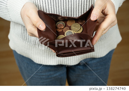 Hands holding an open wallet full of euro coins Hands holding an open wallet full of euro coins 138274740