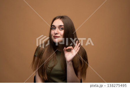 Young woman showing okay sign, expressing approval and agreement, concept of quality and perfection Young woman showing okay sign, expressing approval and agreement, concept of quality and perfection 138275495