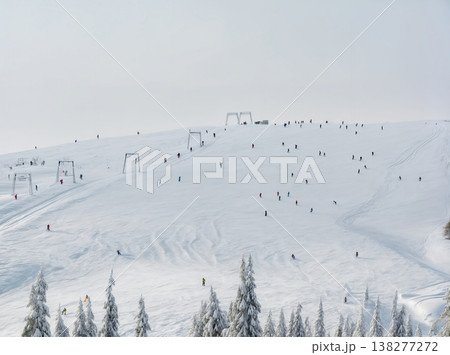 Winter landscape with snow-capped mountains and skiers. Sunlight sparkles on the snow-white slope, creating an atmosphere of adventure and joy. For winter travel, outdoor activities and sports themes 138277272