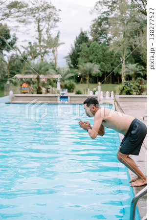 Southeast Asian man about to jump into pool 138277527