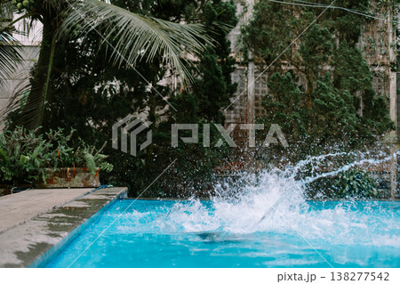 Adult male diving into swimming pool outdoors Adult male diving into swimming pool outdoors 138277542