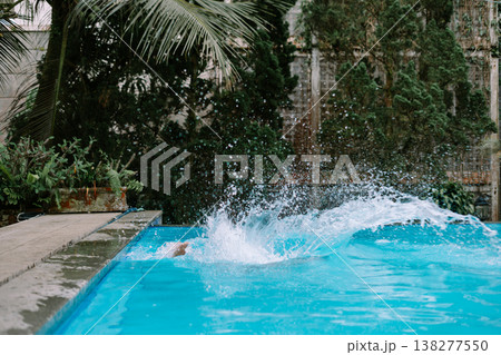Southeast Asian man mid air jump into pool 138277550