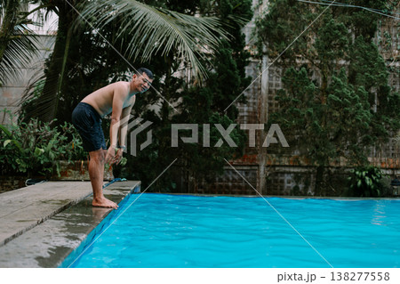 Southeast Asian man jumping into pool with copy space 138277558