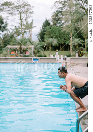 Man diving into swimming pool on a relaxing day Man diving into swimming pool on a relaxing day 138277562