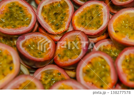 Passion fruit background with half cut chinola. A lot of sliced maracuja. Tropical fruits backdrop. 138277578