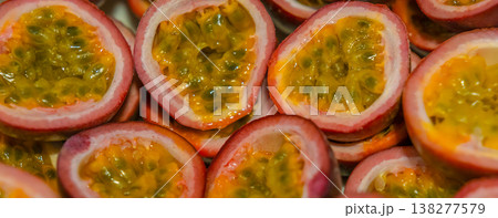 Passion fruit background with half cut chinola. A lot of sliced maracuja. Tropical fruits backdrop. 138277579