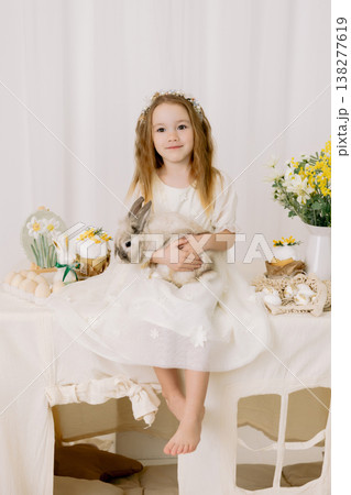 Adorable girl hold bunny in soft Easter decor, bright minimal studio portrait with spring mood Adorable girl hold bunny in soft Easter decor, bright minimal studio portrait with spring mood 138277619