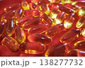 Close up of fish oil capsules scattered on red fabric. Omega 3 supplements, healthy lifestyle and nutrition concept with bright glossy softgel pills. 138277732