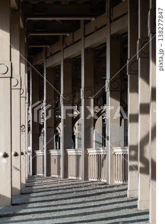 In a sweeping display of 19th-century elegance, the bridge's skeletal arches form a vaulted promenade that stretches toward the horizon. The play of afternoon light filters through the rhythmic iron 138277847