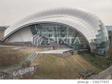 The sinuous, stainless-steel canopy of The Glasshouse International Centre for Music crests like a shimmering glass wave over the industrial landscape. This architectural masterpiece creates a 138277855