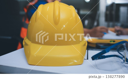 engineer and an architect reviewing blueprints and construction plans together at a bustling construction site 138277890