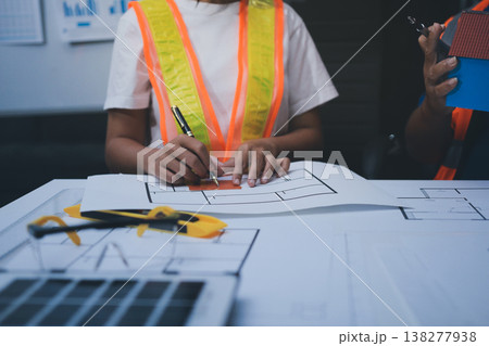 engineer and an architect reviewing blueprints and construction plans together at a bustling construction site engineer and an architect reviewing blueprints and construction plans together at a bustling construction site 138277938
