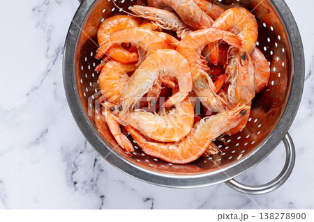 freshly frozen shrimp in a metal colander, for cooking, top view, close-up, on a marble table, no people, freshly frozen shrimp in a metal colander, for cooking, top view, close-up, on a marble table, no people, 138278900