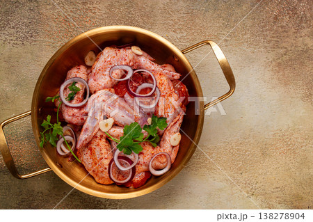 Chicken wings, in a brass saucepan, ready for cooking, grilling or baking, in a home kitchen, no people Chicken wings, in a brass saucepan, ready for cooking, grilling or baking, in a home kitchen, no people 138278904