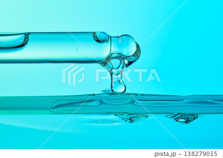Pipette dripping transparent serum onto turquoise liquid surface Pipette dripping transparent serum onto turquoise liquid surface 138279015