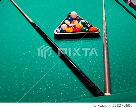 Players gather around a vibrant billiard table, eager to break the rack of colorful balls and engage in spirited competition during game night Players gather around a vibrant billiard table, eager to break the rack of colorful balls and engage in spirited competition during game night 138279696