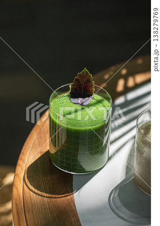 Green smoothie in glass with herb garnish 138279769