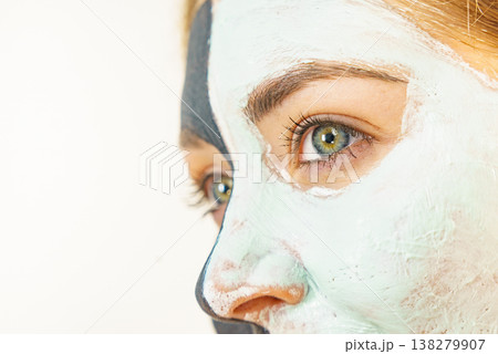 Female applying green mud facial mask Female applying green mud facial mask 138279907