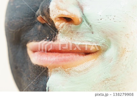 Girl black and green mud mask on face 138279908