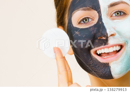 Girl remove black white mud mask from face 138279913
