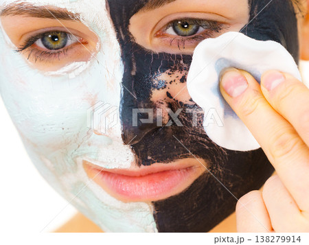 Girl remove black white mud mask from face 138279914