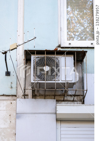 air conditioner is installed on facade of the building. air conditioner compressor is on wall. air conditioner is installed on facade of the building. air conditioner compressor is on wall. 138279957