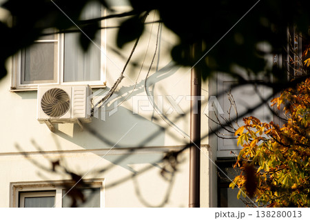 air conditioner is installed on facade of the building. air conditioner compressor is on wall. 138280013