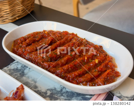 Spicy Turkish ezme spread served in a white dish with rich red pepper and tomato texture. Traditional meze appetizer, restaurant menu presentation and savory condiment for grilled dishes Spicy Turkish ezme spread served in a white dish with rich red pepper and tomato texture. Traditional meze appetizer, restaurant menu presentation and savory condiment for grilled dishes 138280142
