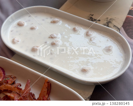 Chickpeas in creamy ayran sauce served in a white dish as a chilled Turkish side. Traditional dairy meze, protein rich appetizer and restaurant menu detail with refreshing texture Chickpeas in creamy ayran sauce served in a white dish as a chilled Turkish side. Traditional dairy meze, protein rich appetizer and restaurant menu detail with refreshing texture 138280145