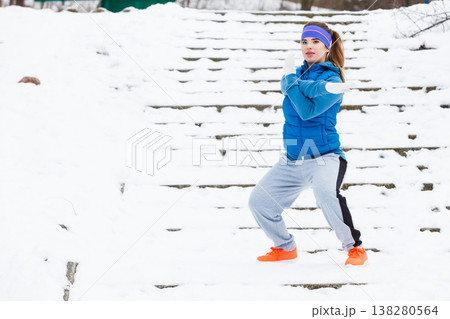 Woman wearing sportswear exercising outside during winter Woman wearing sportswear exercising outside during winter 138280564