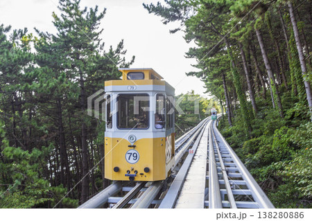 Colorful oceanfront capsule cars travel along an elevated coastal rail, offering scenic seaside views and a relaxed tourism experience over the water. High quality photo 138280886