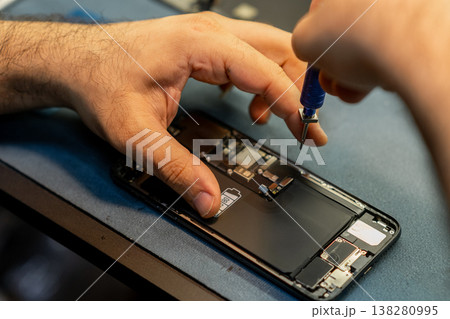 Expert Phone Repair Technician Working on a Smartphone in a Repair Shop During the Day 138280995