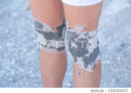 Person With Painted Knees Standing on Gravel Path During an Outdoor Art Activity in Sunlight 138281023
