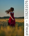 Woman rye field red dress. Happy woman in a long red dress in a beautiful cornfield. Old caste ruins in the background 138281076