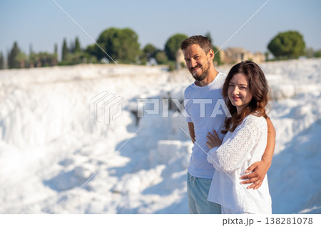 Couple Enjoying the Thermal Terraces of Pamukkale on a Sunny Day, Surrounded by Stunning Natural Beauty and Ancient Ruins Couple Enjoying the Thermal Terraces of Pamukkale on a Sunny Day, Surrounded by Stunning Natural Beauty and Ancient Ruins 138281078