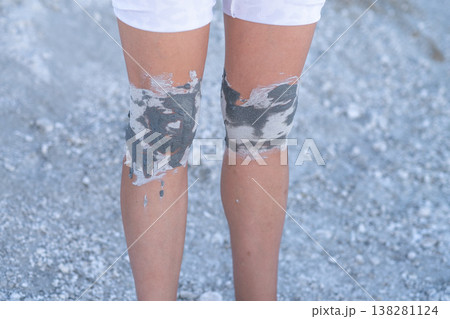 Person With Painted Knees Standing on Light Gravel in Outdoor Setting During Sunny Day, Showcasing Creativity and Artistic Expression 138281124