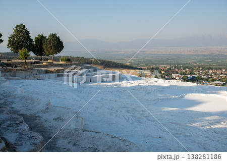 Pamukkales Stunning Travertine Terraces at Sunrise Reveal a Breathtaking Landscape of White Mineral Formations and Lush Green Trees 138281186