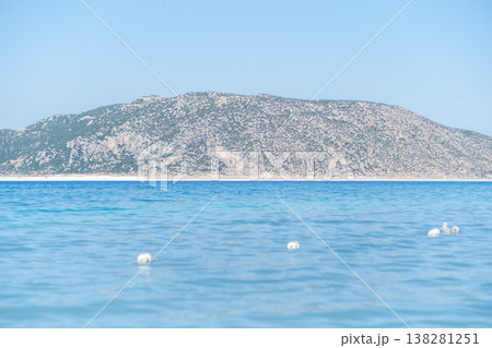 Clear Turquoise Water With Gentle Waves and Distant Rocky Hills Under a Bright Blue Sky at Midday Clear Turquoise Water With Gentle Waves and Distant Rocky Hills Under a Bright Blue Sky at Midday 138281251