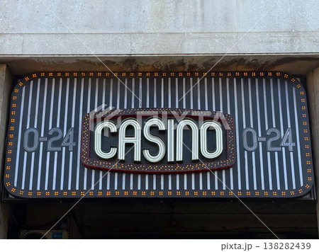 Casino entrance sign symbolizing gambling, risk and the thrill of chance in urban nightlife. Entertainment venue representing luck, high stakes, winnings and leisure activity in the city Casino entrance sign symbolizing gambling, risk and the thrill of chance in urban nightlife. Entertainment venue representing luck, high stakes, winnings and leisure activity in the city 138282439