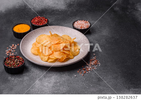 Crispy potato chips, golden slices seasoned with salt and spices. Potato chips 138282637
