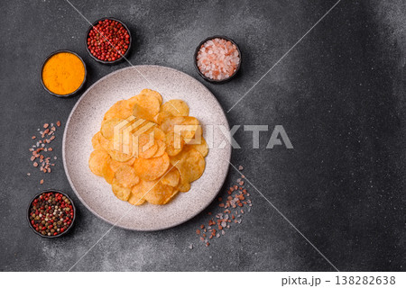 Crispy potato chips, golden slices seasoned with salt and spices. Potato chips 138282638