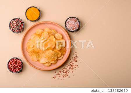 Crispy potato chips, golden slices seasoned with salt and spices. Potato chips Crispy potato chips, golden slices seasoned with salt and spices. Potato chips 138282650