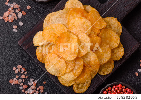 Crispy potato chips, golden slices seasoned with salt and spices. Potato chips Crispy potato chips, golden slices seasoned with salt and spices. Potato chips 138282655
