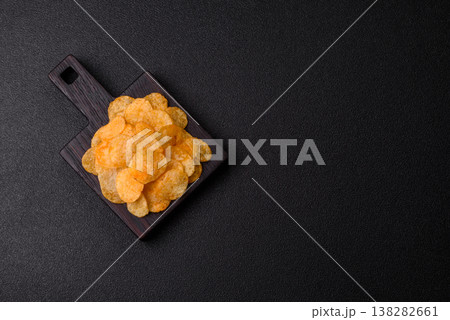 Crispy potato chips, golden slices seasoned with salt and spices. Potato chips 138282661