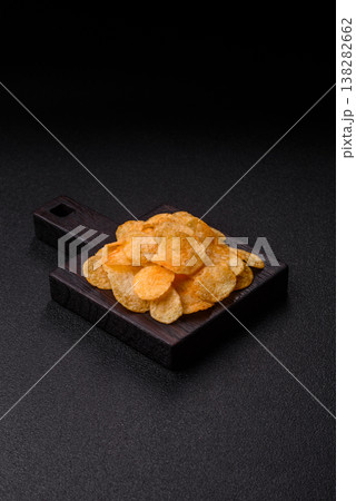 Crispy potato chips, golden slices seasoned with salt and spices. Potato chips 138282662