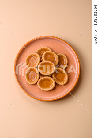 Round mini tartlets with citrus or peach jam and crumbly pastry. Mini citrus tarts 138282664