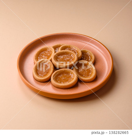 Round mini tartlets with citrus or peach jam and crumbly pastry. Mini citrus tarts Round mini tartlets with citrus or peach jam and crumbly pastry. Mini citrus tarts 138282665