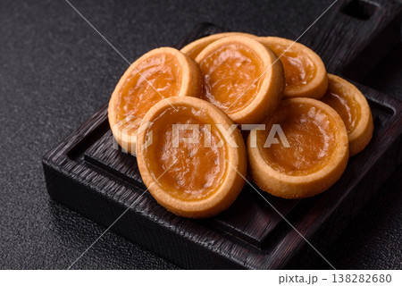 Round mini tartlets with citrus or peach jam and crumbly pastry. Mini citrus tarts Round mini tartlets with citrus or peach jam and crumbly pastry. Mini citrus tarts 138282680